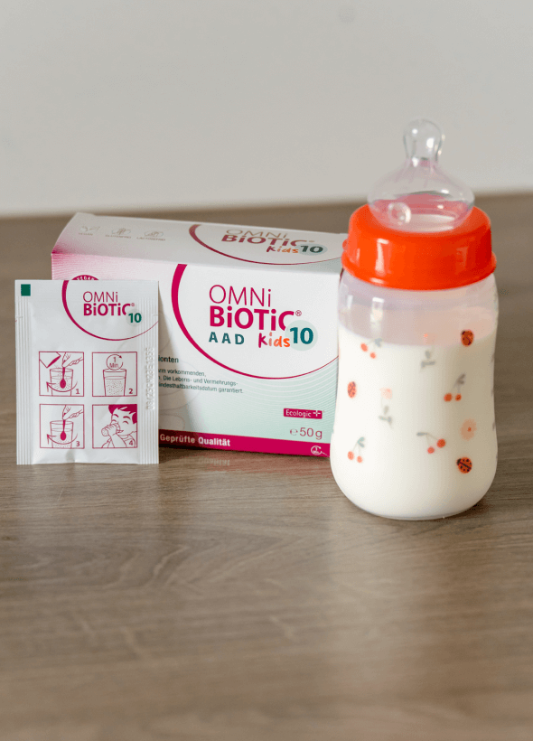 Probiotyk OMNi-BiOTiC® 10 AAD Kids na tle piłek